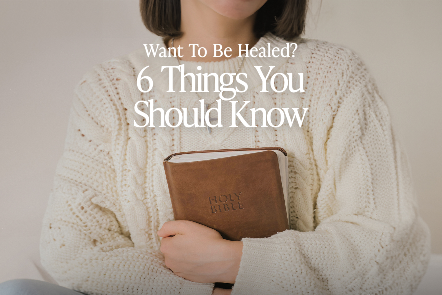 Woman wearing a white sweater and holding a bible to her chest